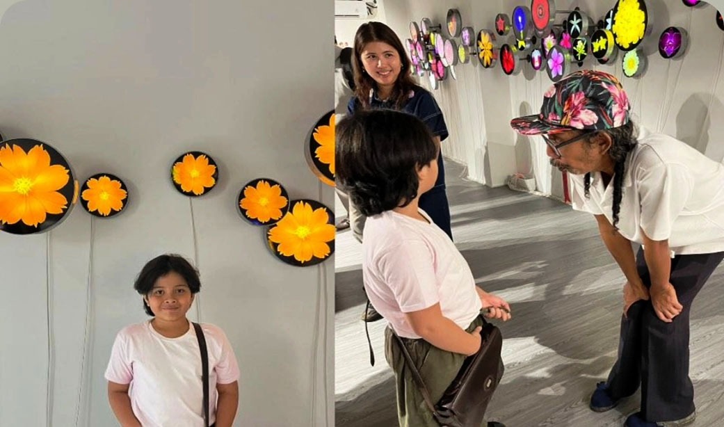Pelukis Angki tengah mendengar apresiasi salah anak terhadap karyanya saat pembukaan pameran Berbunga bunga