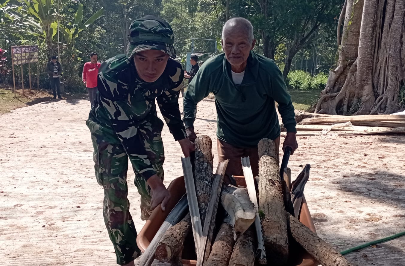Anggota Satgas TMMD Reguler ke-129 Tahun 2026 Ringankan Beban Warga Bantu Dorong Angkong Berisi Kayu Bakar